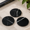 Black natural marble round coasters with white veining
